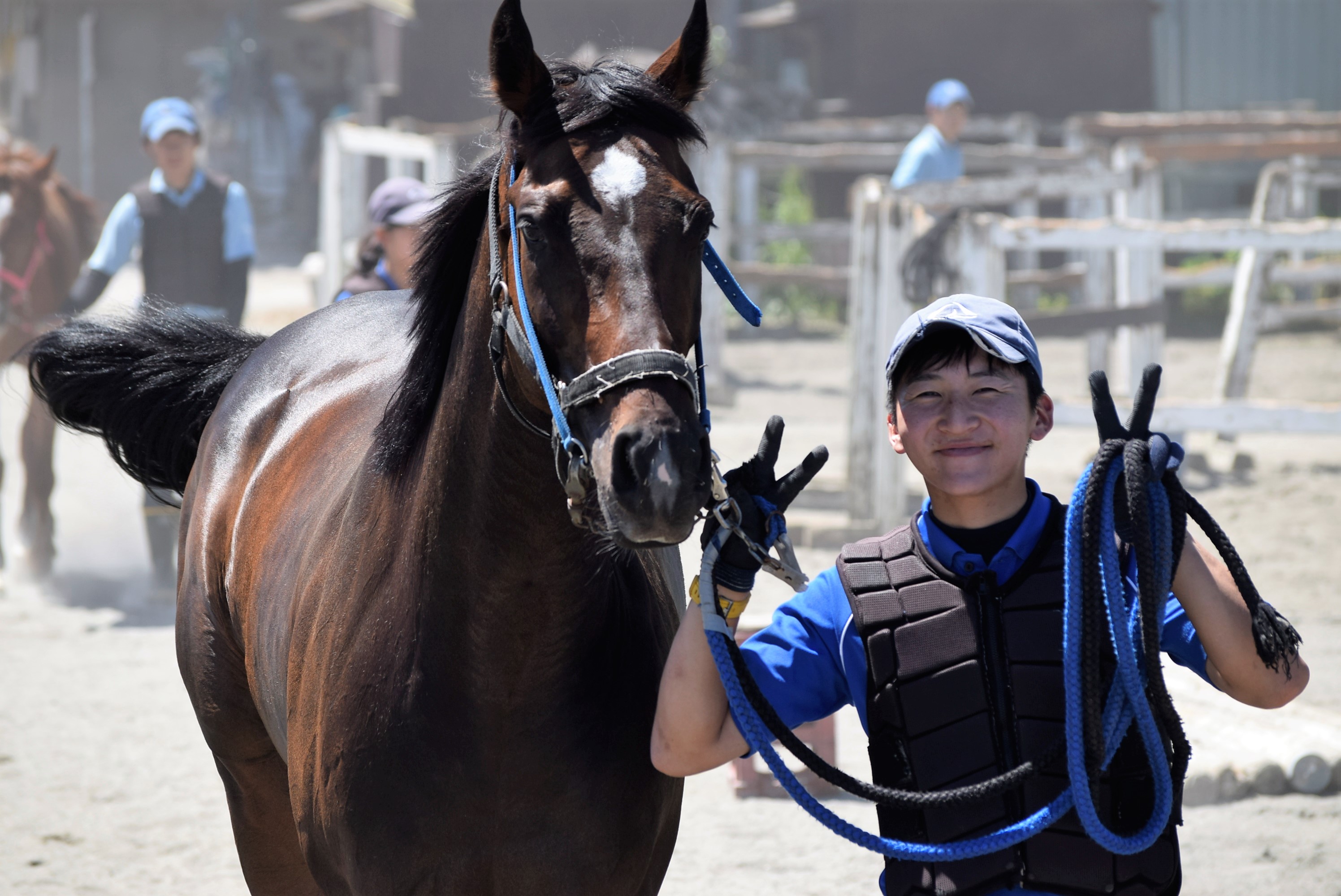 笑顔で馬と並ぶ学生